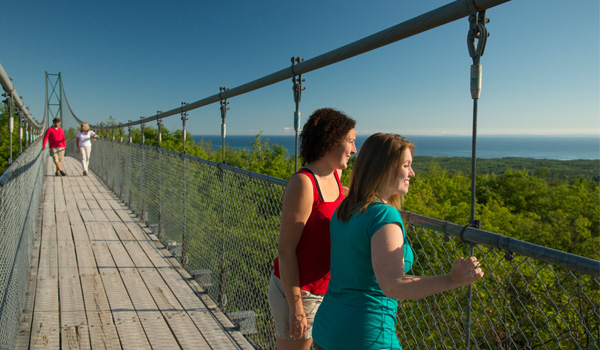 Two women on the scenic caves suspension bridge enjoying the view of Georgian Bay