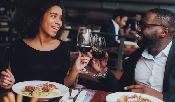 couple enjoying wine and food at a restaurant