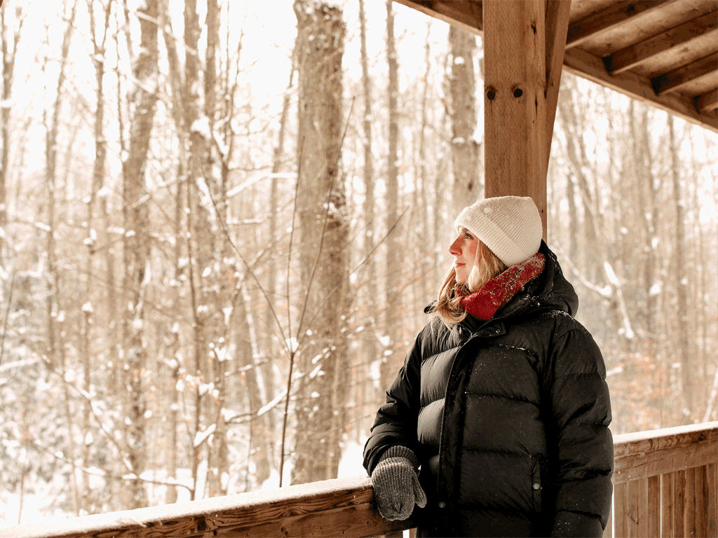 Girl standing on path way looking out at trees in winter