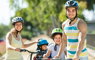 Family of four smiling during a cycling ride