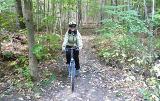 Woman cycling through a forest trail in the fall