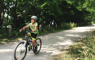 Little boy cycling on a rail trail