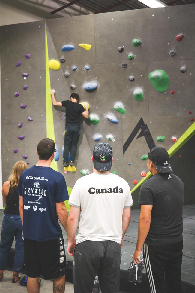 3 guys watching someone climb wall