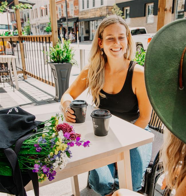 LAF_6268-HomesteadPatioedit woman smiling at another woman with coffee in hand
