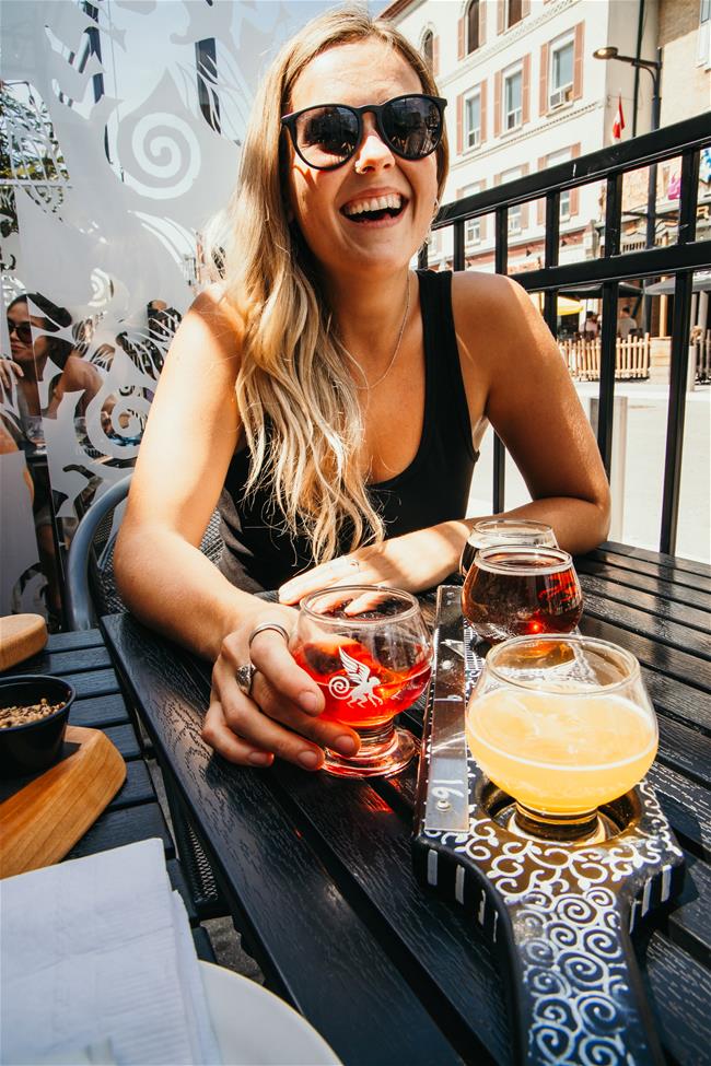 sitting woman smiling with beers on table