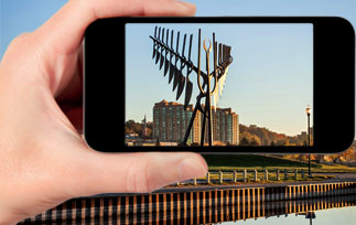 Hand holding a phone taking a picture of the Barrie spirit catcher for a gallery