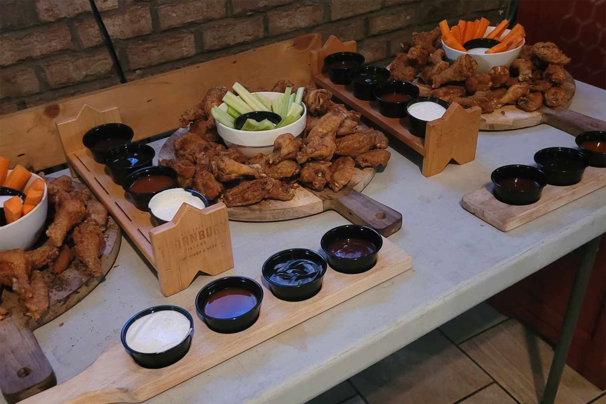 Chicken wings and dips on a table prepared by CW Coop.