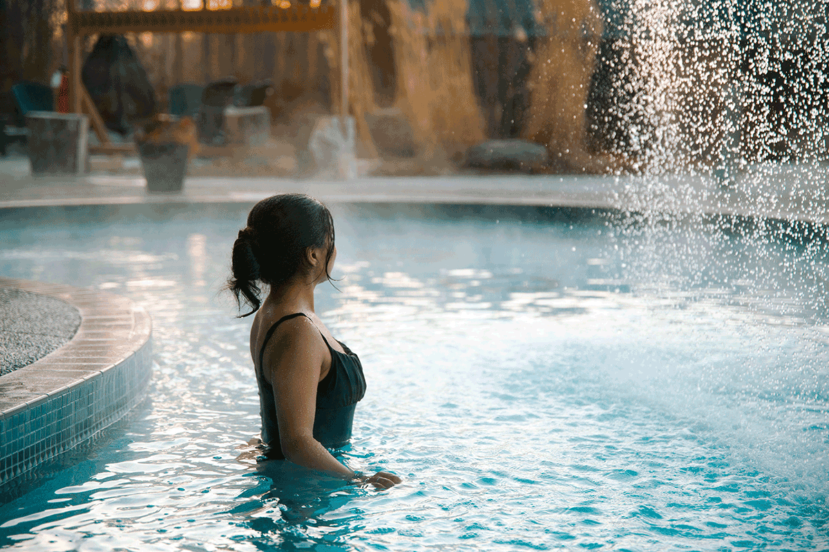 Person relaxing in Kerata outdoor pool at Vetta Nordic Spa