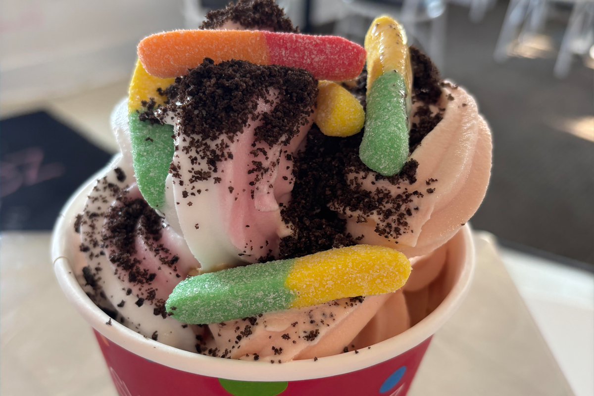 Frozen yogurt with gummy worms and crushed cookies