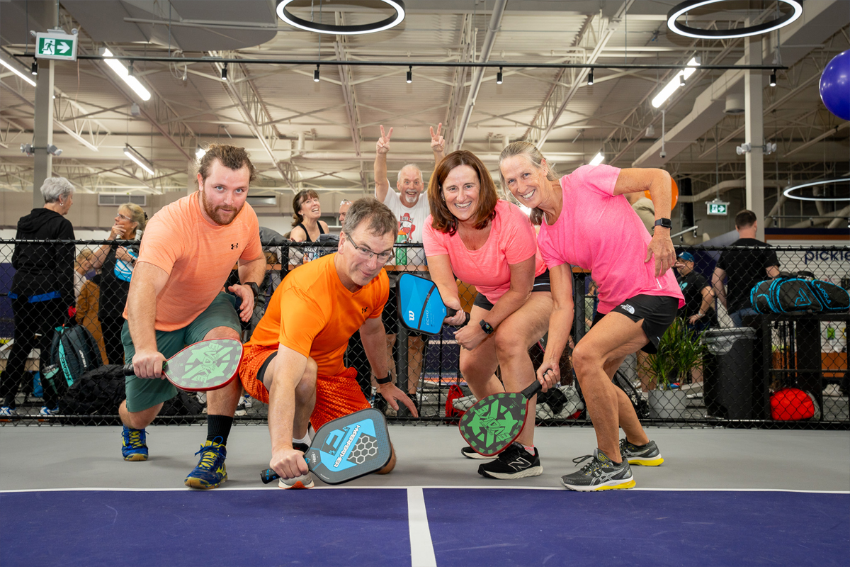 Group of people posing on pickleball court