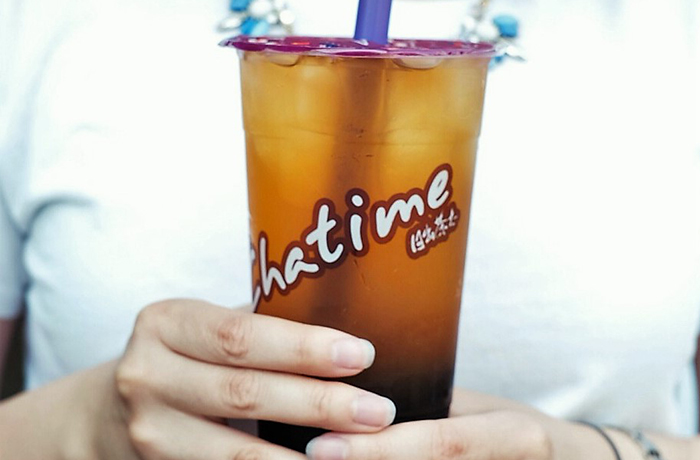 Person in a white shirt holding a Chatime drink
