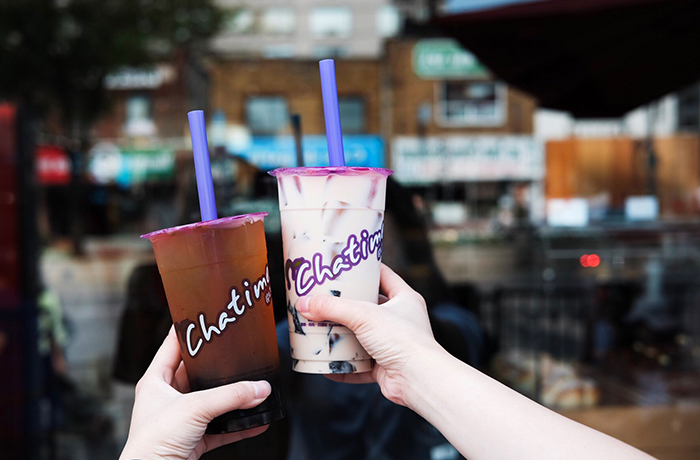 Two hands holding up Chatime drinks