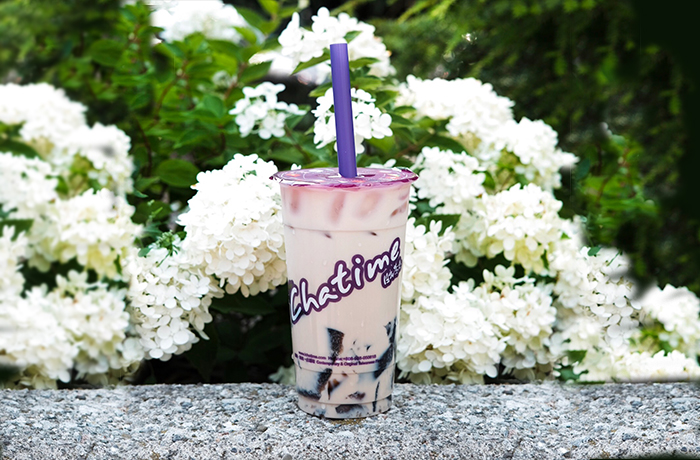 Chatime drink in front of white flowers
