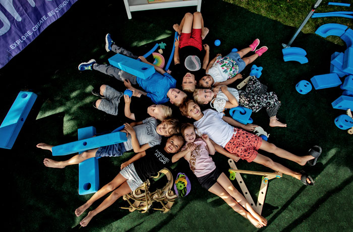 Picture of Curio kids laying in a star pattern taken from above