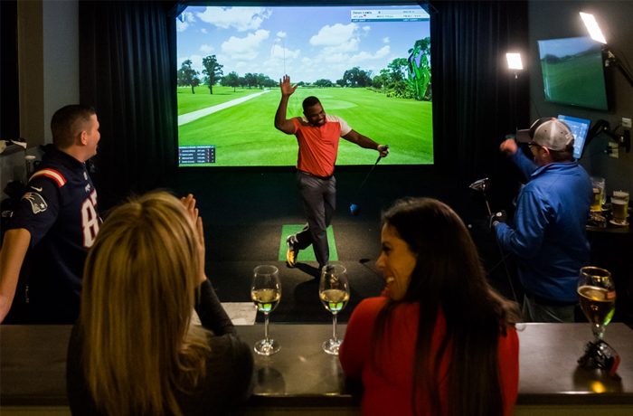 Friends celebrating a great virtual shot at North Swing Golf lounge Barrie