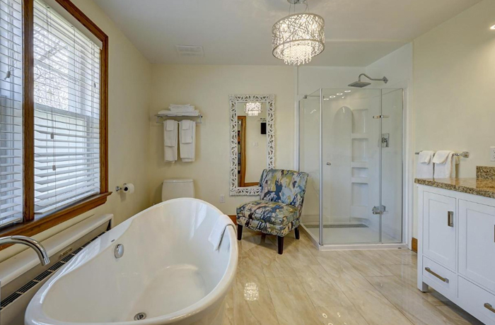 Parkside House bathroom with clawfoot tub and shower in the background