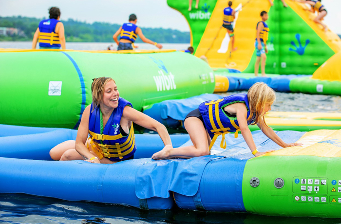 Mom and daughter laughing and having fun on Splash ON water park inflatable obstacle course