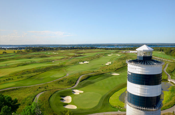 Drone shot of The Nest golf course at Friday Harbour with the tower in front right and Lake Simcoe in the background